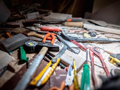 L’atelier décors : l’établi, le tableau d’outils au mur, les caisses au sol.
