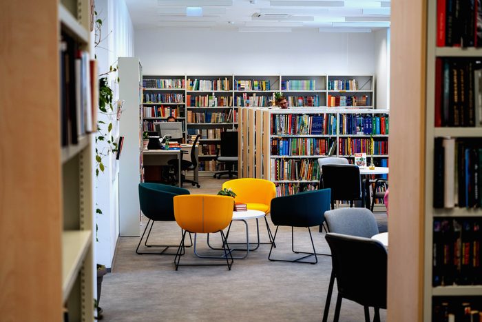 Une lecture dans la salle, les chaises tournées vers l’estrade.