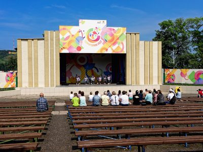 Le spectacle en plein air : l’estrade montée sur l’herbe, les chaises devant.