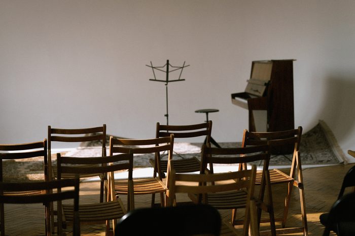 La troupe adulte en répétition, chaises et pupitres en demi-cercle.
