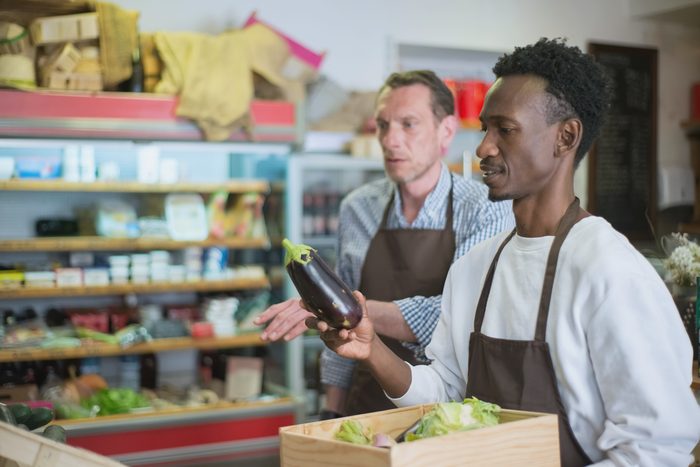L’épicerie : les cagettes de légumes sur la table, dans le local clair.