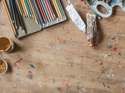 L’atelier ouvert : deux grandes tables, du matériel étalé, trois personnes penchées.