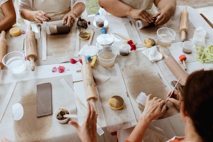 L’atelier : les tables en îlot, le matériel étalé, des personnes penchées.
