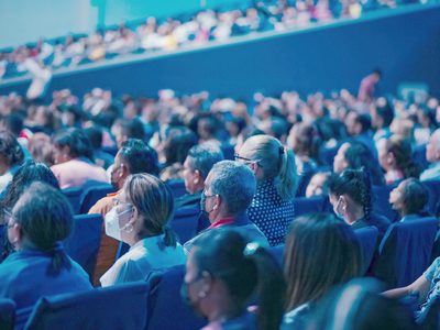 L’auditorium : l’écran, la table, le public de dos.