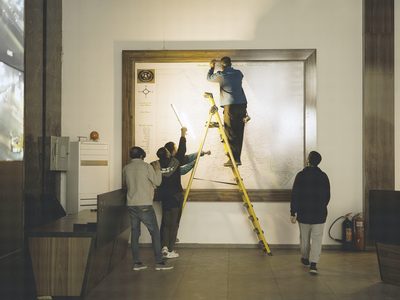 Le montage : l’escabeau et une œuvre appuyée contre le mur.