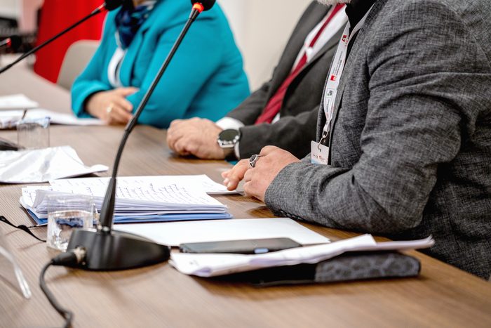Une assemblée : la tribune, la banderole, les rangs de chaises.