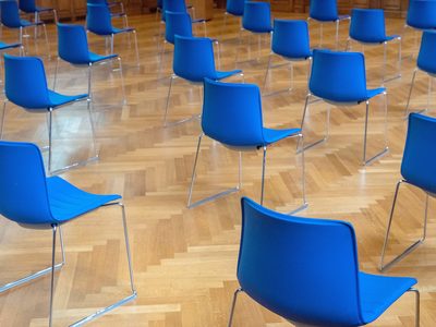 Une réunion publique : l’écran, la table, deux rangs de chaises.